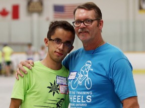 Joshua Gaudette, left, and and Frank Harshaw work at the ICan Bike event at South Windsor Arena in Windsor, Ontario on July 19, 2016.