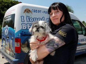 Windsor/Essex County Humane Society animal control officer Natalie Crerar holds stray dog, Zoe in front of her animal relief vehicle Wednesday July 20, 2016.