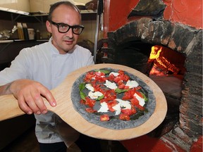 Giovanni Caboto Club pizza maker Remo Tortola prepares to cook a pizza made with a black dough on Wednesday July 20, 2016.