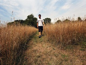Area resident Haitham Debaja walks through tall grass in the area of Seven Sisters Park Friday July 29, 2016.