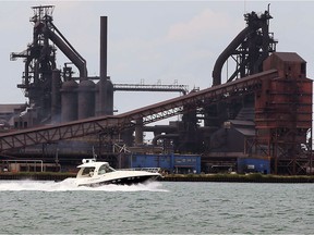 Pleasure boat passes in front of a huge industrial complex on Zug Island, located on the U.S. side of the Detroit River, Thursday July 21, 2016.