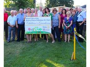 Windsor-St. Clair Rotary Club members hold a banner at the site of its new greenhouse project outside of the Regional Children's Centre Huot Building, on Thursday, July 7, 2016