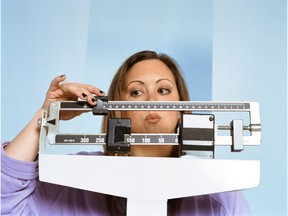 Woman on scale. Measuring weight. Obesity. Photo by Getty Images.