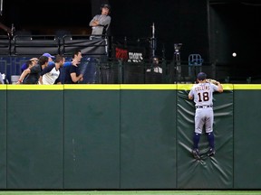 Detroit Tigers center fielder Tyler Collins and fans watch the home-run ball of Seattle Mariners' Nelson Cruz go over the outfield wall during the eighth inning of a baseball game Wednesday, Aug. 10, 2016, in Seattle. (AP Photo/Elaine Thompson)