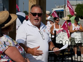 Richard Meloche and Mary Ellen Morton-Collins, left, open McGregor Parkette as striking CUPE members move their picket line a few metres south on Walker Road to join the ribbon cutting ceremony Aug. 4, 2016. Meloche also serves on the negotiating committee for Essex County Library. (NICK BRANCACCIO/Windsor Star)