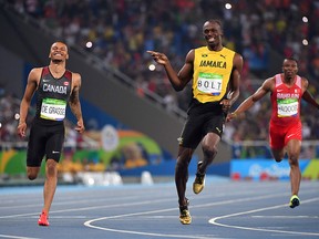 Jamaica's Usain Bolt (C) jokes with Canada's Andre De Grasse (L) after they crossed the finish line in the Men's 200m Semifinal during the athletics event at the Rio 2016 Olympic Games at the Olympic Stadium in Rio de Janeiro on August 17, 2016.