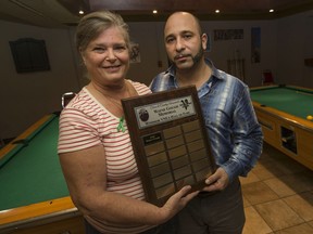 Cheryl McWilliams, mother of Wayne Gough, and Rob Chiarenza hold the Wayne Gough Memorial plaque that will recognize local pool players.