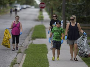 From left, Linda Buchanan, Francine Doucette, Caleb Dunne, 8, and Melissa Dunne pick up trash on Assumption Street for the cleanup and block party put on by the Glengarry-Marentette community, Saturday, August 27, 2016.