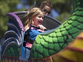 A young girl is all smiles as she takes a ride on the Dragon ride at the 157th Comber Fair, Saturday, July 6, 2016.