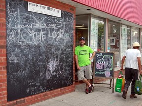 John Thompson of the Downtown Windsor Community Collaborative stands by the giant blackboard set up at the DWCC's storefront office at 395 Wyandotte St. West.