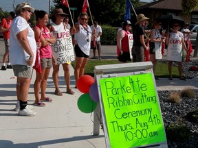 Striking CUPE members move their picket line on Walker Road to join a ribbon cutting ceremony at McGregor Parkette August 04, 2016. Essex Deputy Mayor Richard Meloche, a negotiator with Essex County Library, attended the ribbon cutting event.