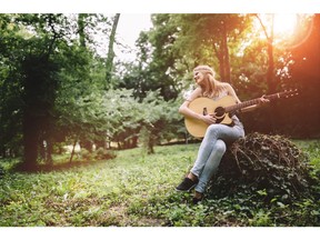 Playing guitar outdoors. Photo by Getty Images.