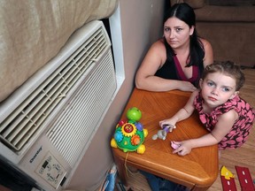 Amanda Banwell and her daughter Brookelynn Hofsteteris, 3,  sit next to the air conditioner in their living room on Aug. 19, 2016.