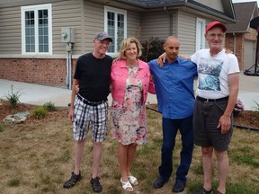 Craig Demers, Reggie Wilson and Tim Wilson, people supported by Community Living Essex County, pose with  MPP Helena Jaczek, minister of community and social services, outside of their home in Essex on Aug. 15, 2016.