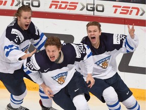 Finland's Vili Saarijarvi, right, and Joni Tuulola, left, celebrate Kasperi Kapanen's game-winning goal in overtime against Russia in gold-medal game hockey action at the IIHF World Championship, in Helsinki, Finland, on Jan. 5, 2016.