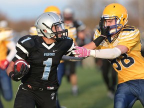 Villanova Wildcats Jacob Savoni scores a touchdown while while defended by Ste. Anne Saints Mitchell Zimmerman during WECSSAA senior boys high school football action in Lakeshore, Ontario on Nov. 6, 2015.