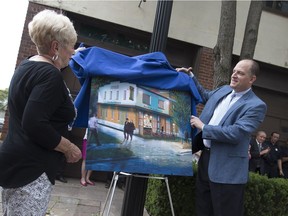 Carol Muir, widow to the late John Muir, left, and mayor Drew Dilkens unveil an artist's illustration of a new library branch to be built in the old Sandwich fire station, Sunday, July 31, 2016.  The branch will be dedicated in honour of the late John Muir.
