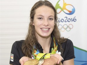 Canada's Penny Oleksiak, from Toronto, holds up her four medals, a gold, silver and two bronze, she won at the 2016 Summer Olympics during a news conference on Aug. 14, 2016 in Rio de Janeiro, Brazil.