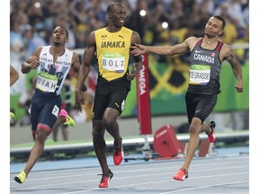 RIO-OLYMPICS-POSTMEDIA  RIO, ONTARIO : August 15, 2016 - Andre De Grasse, of Canada (right), reacts after coming second to Usain Bolt (middle), of Jamaica, in the men's 100m semifinal at the Rio 2016 Olympic Games in Rio de Janeiro, Brazil, , Monday, August 15, 2016.   (Tyler Anderson / National Post)  (For Postmedia Olympic Coverage)