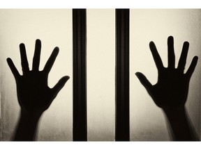 Female hand silhouette on the glass. Image of human trafficking. Photo by Getty Images.