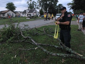 A LaSalle police officer tapes off a section of Victory Street following a tornado on Wednesday, August 24, 2016.
