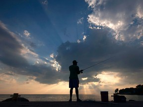 A man casts his line while fishing off the pier at the Colchester Harbour Marina, Sunday, July 31, 2016.
