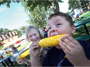 Declan Sampson, age 4, takes a big bite out of a cob of corn as his grandmother Nancy Topolnicki looks on at the Tecumseh Corn Festival in Tecumseh, Ontario on August 26, 2016.