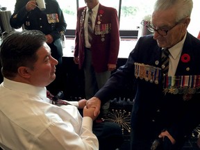Veterans affairs Min. Kent Hehr shakes the hand of Windsor's Larry Costello at an announcement for the re-opening of the Veterans Affairs Canada office in Windsor.