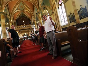 Kevin Mannara, from the Assumption Church Parish, right leads a tour of the Assumption Church during an open house in Windsor on Monday, August 15, 2016.