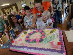 Margaret (Peggy) Chamney gets a hand from Banwell Gardens staff member Renee St. Pierre and her great-great-grandchildren Anabelle and Lukas Sartori as she celebrates her 105th birthday with family and fellow Banwell residents in Windsor on Tuesday, Aug. 9, 2016.