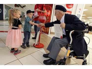 Dec. 23, 2014: Karlin and Dylan Mellow are greeted by Raymond Pease as veterans helped the Salvation Army with their annual kettle campaign at the Devonshire Mall.