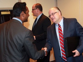 Rakesh Naidu, left, Interim CEO WindsorEssex Economic Development Corp. greets new CEO C. Stephen MacKenzie, right, during press conference at Best Western Riverfront Hotel Monday August 08, 2016.