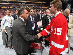 Red Wings GM Ken Holland, left, shakes the hand of Vili Saarijarvi, 73rd overall pick by Detroit during the 2015 NHL Draft on June 27, 2015 in Sunrise, Fla.