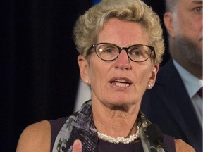 Ontario Premier Kathleen Wynne speaks at a news conference while Quebec Premier Philippe Couillard, right, looks on, Friday, September 11, 2015 at the beginning of a joint cabinet meeting between Ontario and Quebec in Quebec City. THE CANADIAN PRESS/Jacques Boissinot