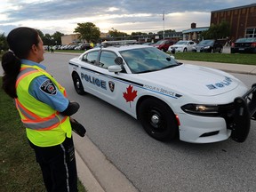 A city of Windsor by-law officer and a Windsor Police officer are shown at the St. John Vianney Catholic on Wednesday, Sept. 28. 2016, where by-law officers were conducting another parking ticket blitz. (DAN JANISSE/The Windsor Star)