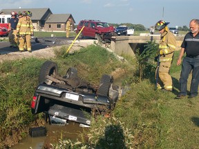 Tecumseh Firefighters, Ontario Provincial Police officers, and Essex-Windsor EMS paramedics work the scene of a two-vehicle accident on Baseline Rd at the 11th Concession in Tecumseh, Ontario on Sept. 6, 2016. At least 2 patients were transported to hospital with unknown injuries. Ontario Provincial Police are investigating the accident. (JASON KRYK/Windsor Star)