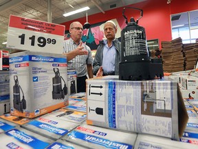 Canadian Tire general manager, Phil Giacalone (L) put in a special emergency response order for sump pumps, mops and fans. He talks to customer Nusrat Mustapha at the east Windsor location on Friday, Sept. 30, 2016. (DAN JANISSE/The Windsor Star)