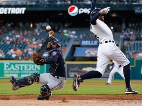 Detroit Tigers' Cameron Maybin, right, avoids Minnesota Twins catcher Kurt Suzuki on his way to score on a Miguel Cabrera single as the throw gets away during the first inning of a baseball game in Detroit, Tuesday, Sept. 13, 2016. (AP Photo/Paul Sancya)