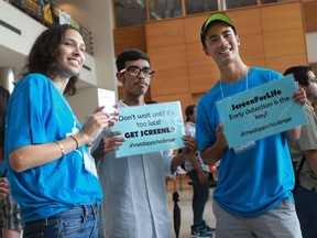 Katherine Fleshner, left, and Nathan Tam, right, first-year medical students from Western University’s Schulich School of Medicine & Dentistry, provide cancer screening awareness information to first-year business student Bonny Ghosh Sept. 8, 2016 at the University of Windsor.