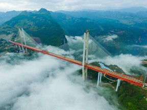 This picture taken on September 10, 2016 shows the Beipanjiang Bridge, near Bijie in southwest China's Guizhou province. Chinese engineers linked the two ends of the bridge on September 10, completing the structure of what is expected to become the world's highest bridge. The bridge soars 565 meters (1,854 feet) above a river in the mountainous region. /