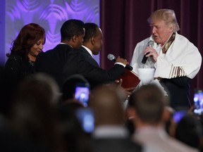 Republican presidential candidate Donald Trump wears a prayer shawl as he is presented with a gift during a church service at Great Faith Ministries, Saturday, Sept. 3, 2016, in Detroit.