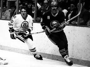 In this undated photo from the 1970s, Richie Dunn, right, of the Buffalo Sabres and Al Secord of the Boston Bruins skate behind the net.