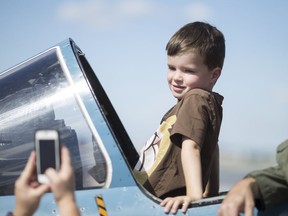 Bennett Griffin, 6, poses for a photo taken by his mother, Jennifer Lavery, while sitting in a Dornier Alpha Jet at the 4th Annual Top Guns Kids in Flight Charity Air Display at Windsor International Airport Sunday, Sept. 11, 2016.