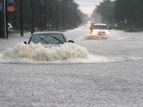 A car chugs through a flooded out section of Lesperance Road near Riverside Drive on Sept. 29, 2016, in Tecumseh. Heavy rains caused flooding in much of the area.