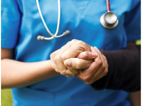 A doctor holds a patient's hand in this photo illustration.