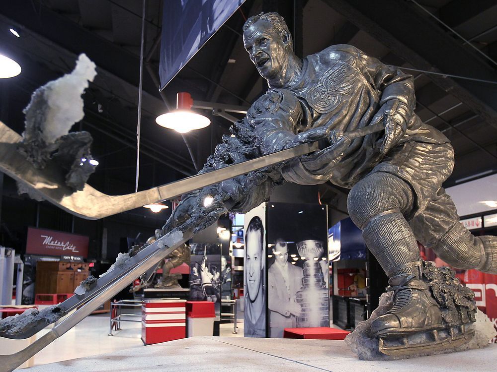 Detroit Red Wings fans paint tributes on the ice at the Joe Louis