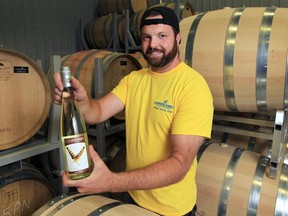 Adam Graham, winemaker and vineyard manager at the Cooper's Hawk Vineyards displays a bottle of the winery''s 2014 Touché white wine on Friday, Sept. 2, 2016.