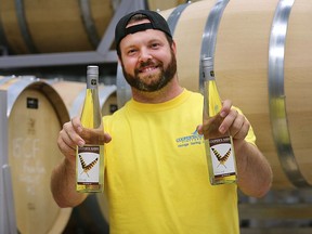 Adam Graham, winemaker and vineyard manager at the Cooper's Hawk Vineyards displays bottles of the winery''s 2014 Touché white wine on Friday, Sept. 2, 2016.