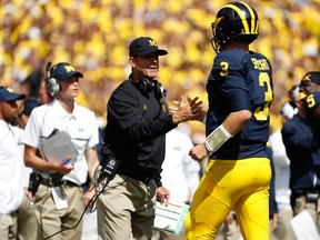 Head coach Jim Harbaugh of the Michigan Wolverines congratulates Wilton Speight #3 on a first quarter touchdown pass on September 3, 2016 at Michigan Stadium in Ann Arbor, Michigan.