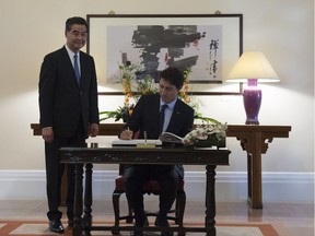 Canadian Prime Minister Justin Trudeau signs the guest book as Hong Kong Chief Executive Leung Chun-ying look on at Government House in Hong Kong,  Tuesday September 6, 2016.